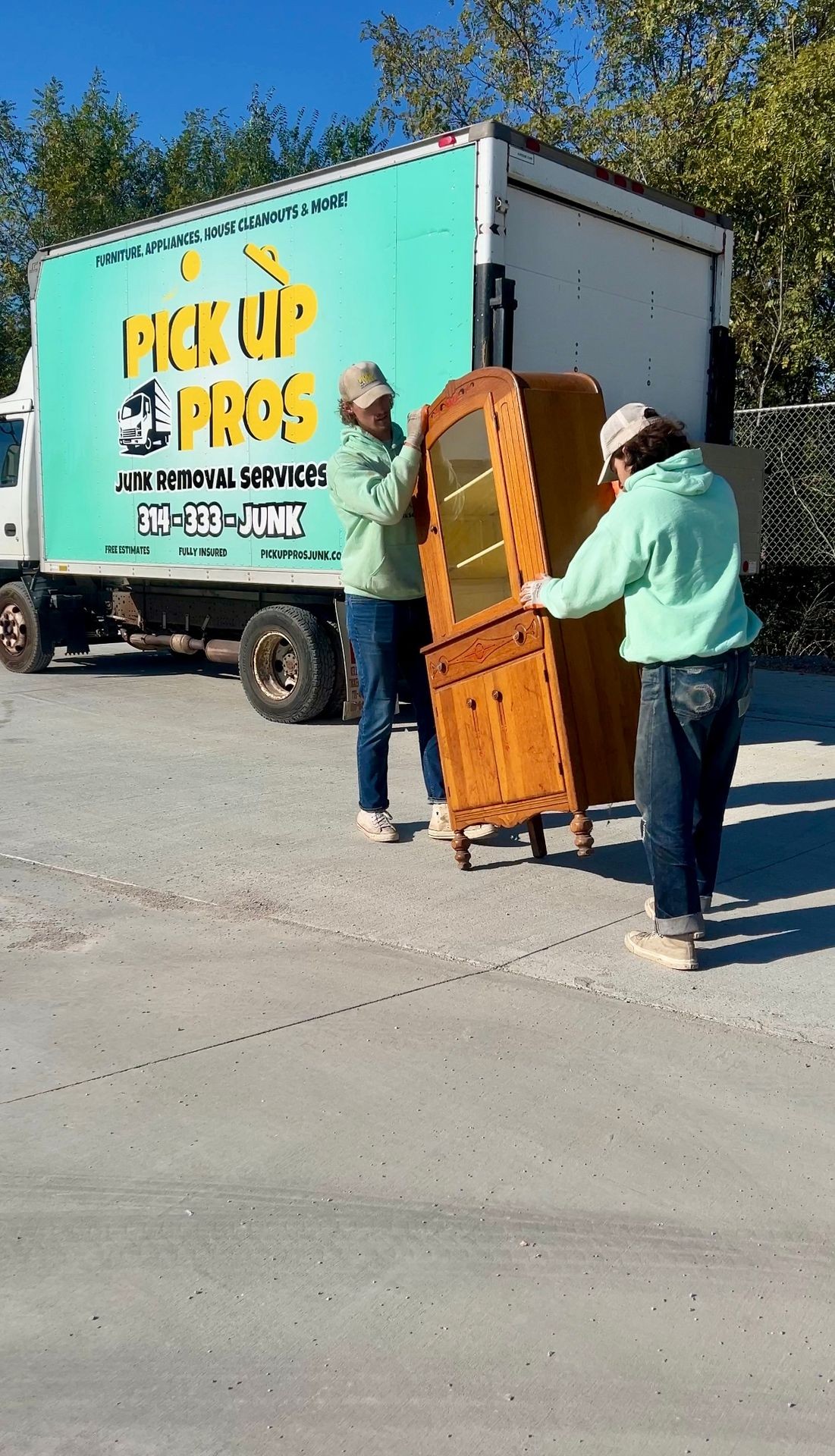 two junk removal experts removing furniture from a home in st louis